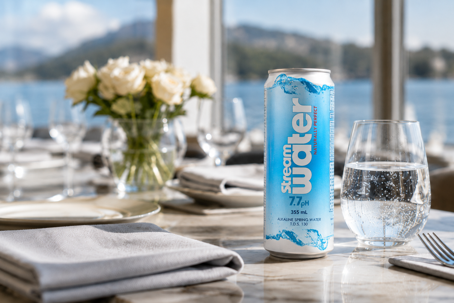 Stream Water aluminum can on a premium hospitality table beside a water glass